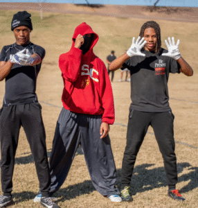 Three athletes warming up together wearing training gloves