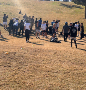 Group of athletes running a conditioning drill on a dirt field